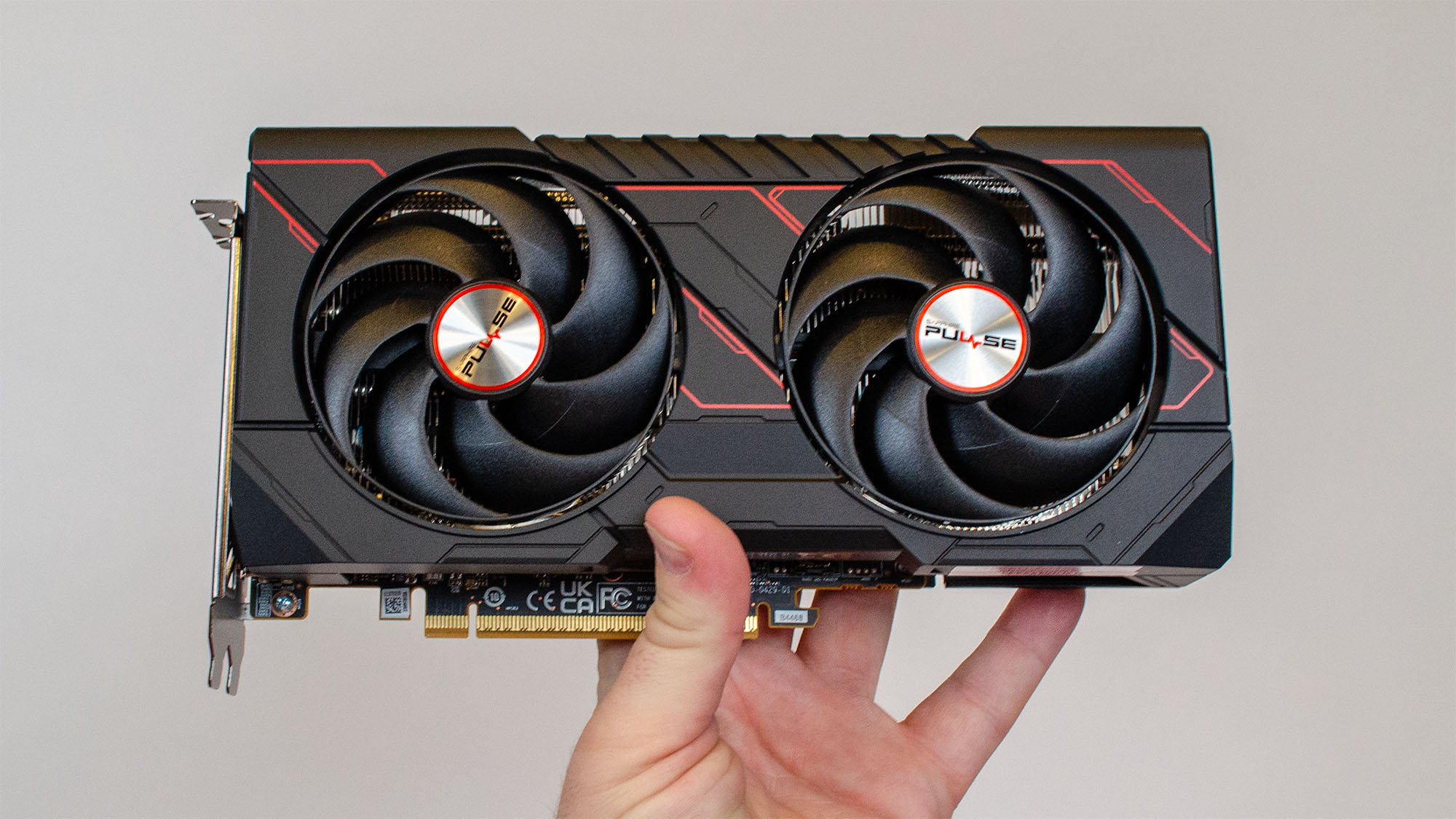 A male hand that supports an AMD Radeon Rx 9060 XT
