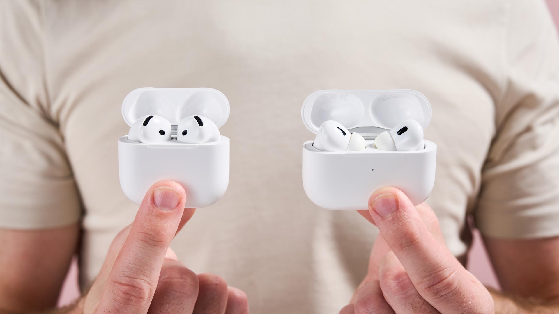 Open cases for Airpods Pro 2 and Airpods 4 are kept next to each other, which show the upper part of the headphones appearing