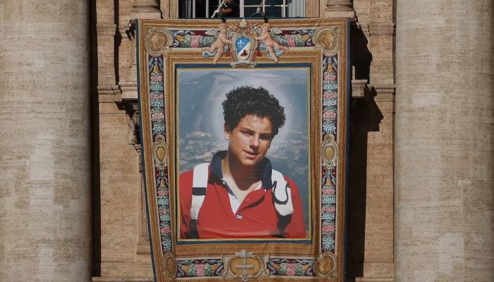 The workers install a tapestry on the facade of St. Peters Basilica in the Vatican that represents an image of Carlo Acutis, an Italian child born in British who will become the first millennium that became a Catholic saint in a ceremony directed by Pope Leo, as seen from Rome, Italy, on September 4, 2025.