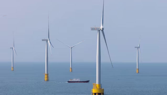 A ship navigates between wind turbines in the Taiwan Strait off the coast of the island of Pingtan, Fujian province, China, April 10, 2023. - Reuters