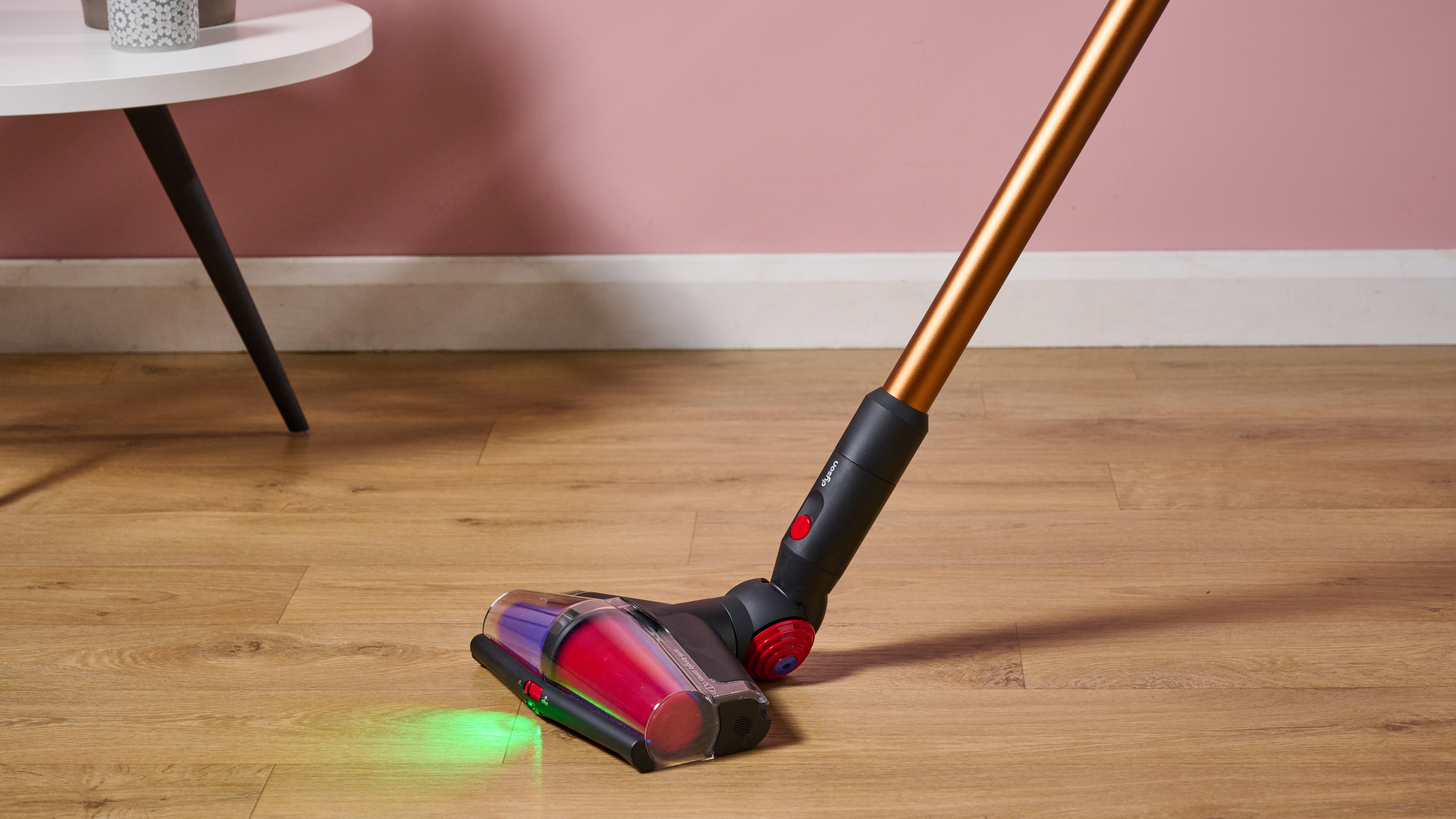 Laser on the floor of the wireless stick vacuum of dyson v16 piston animal, illuminating a wooden floor