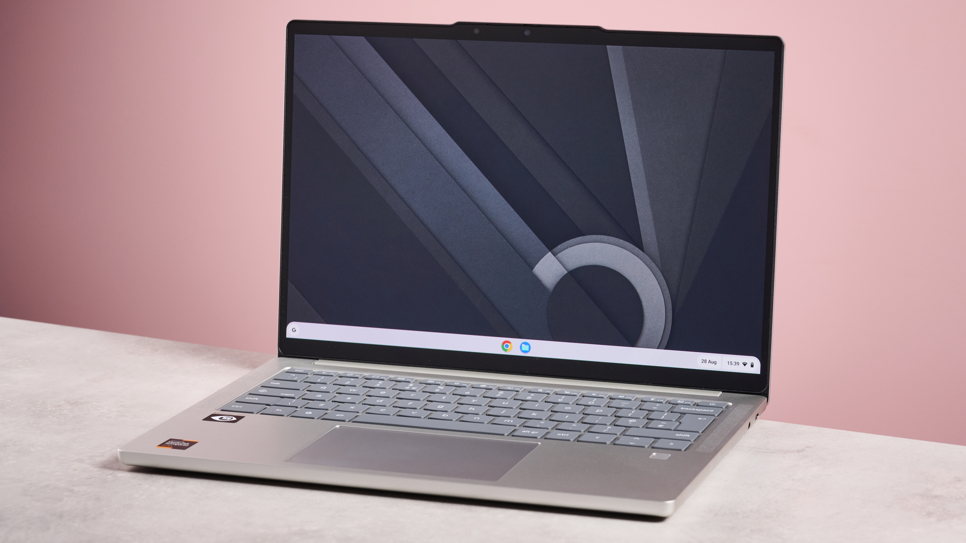 Lenovo Chromebook plus 14 inches open on the desktop with pink background