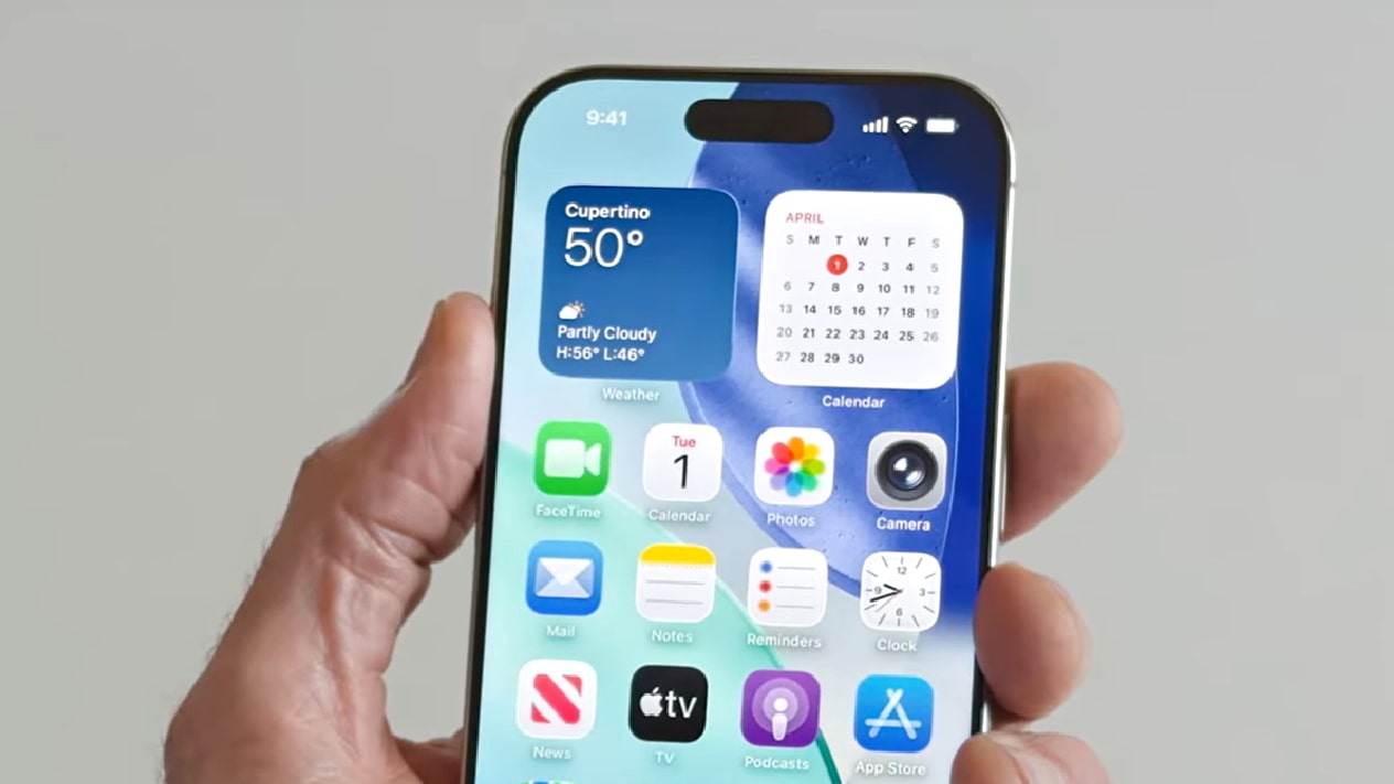 A person holding an iPhone with iOS 26.