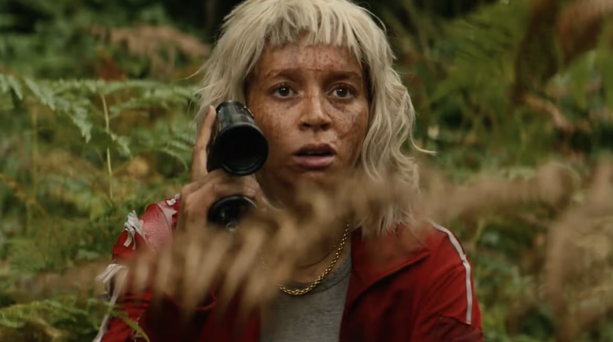Alfie Williams like Spike, wearing a blonde wig and red tracksuit