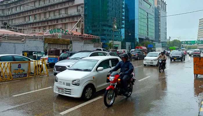 The vehicles pass in Karachis II Chundrigar Road in the middle of the light rain. - PakGazette.tv/file