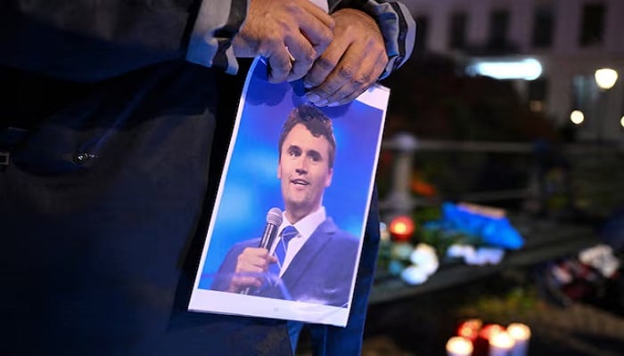 A man has a photo of Charlie Kirk during a vigil under the line in Memory of Charlie Kirk, for freedom, patriotism and justice in front of the United States embassy after the activist of the United States right, commentator, Charlie Kirk, an ally of the president of the United States, Donald Trump, was shot dead during an event in Utah Valley University, OEM, OEM. UU., In Berlin, Germany, 11, 11, 2025.