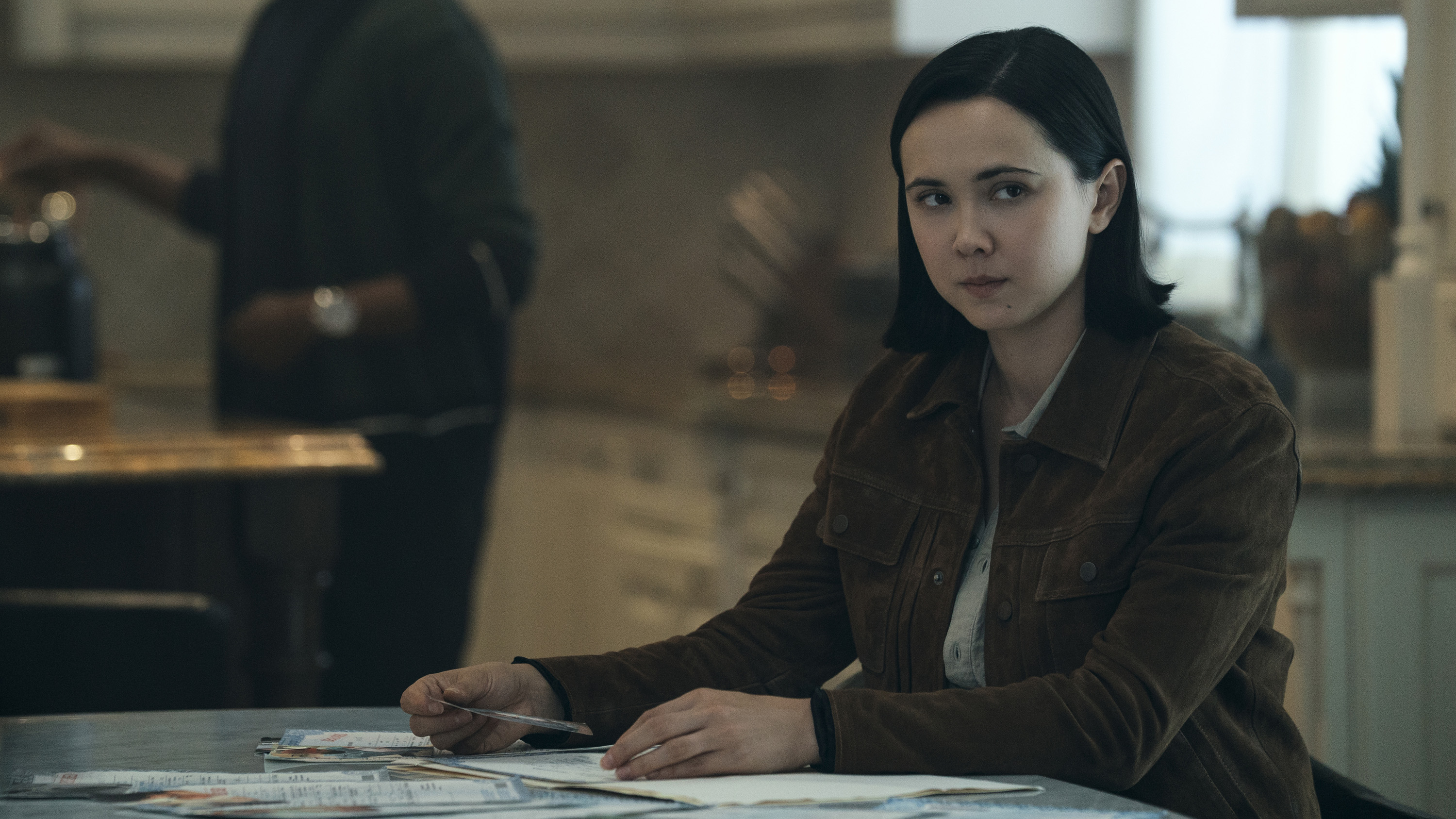 The feminine form of Jordan Li sitting at a table in generation V of season 2