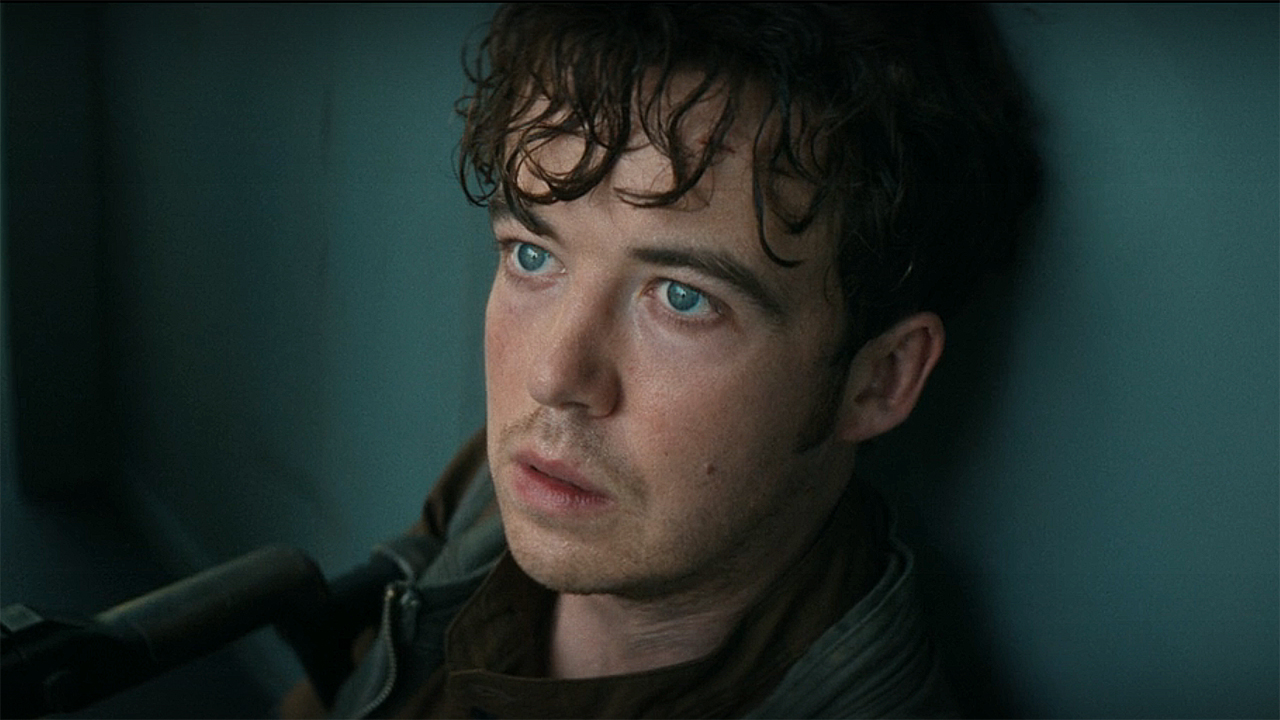 A foreground of cj hermit sitting against a wall in a boat in alien: Earth episode 7