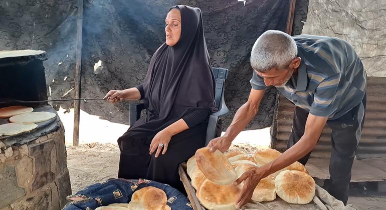 Um Mohammed Abu Zuaiter working with her husband in her clay oven