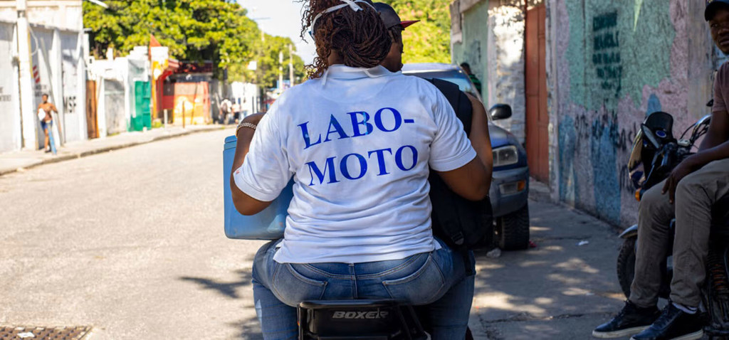 A health worker from 'Labo Moto' travels by motorcycle to visit a patient.