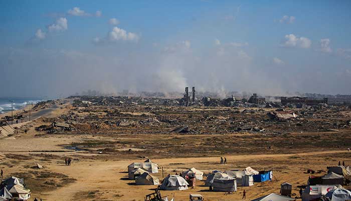 Palestinians walk around tents in Nuseirat, central Gaza Strip, on October 10, 2025. – AFP