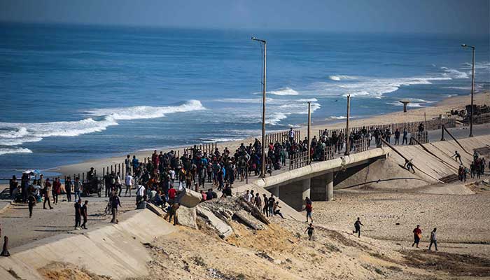 Palestinians gather on a street in Nuseirat, central Gaza Strip, on October 10, 2025. – AFP