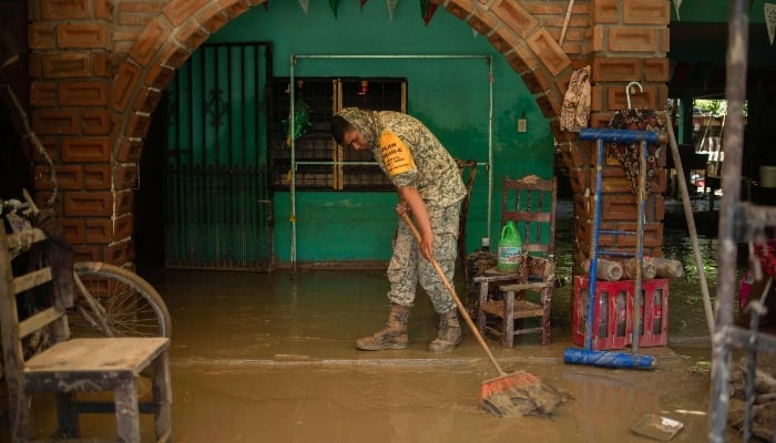A Mexican army soldier works to remove mud from a house flooded by heavy rains in the municipality of Álamo, Veracruz, Mexico, on October 12, 2025. — AFP