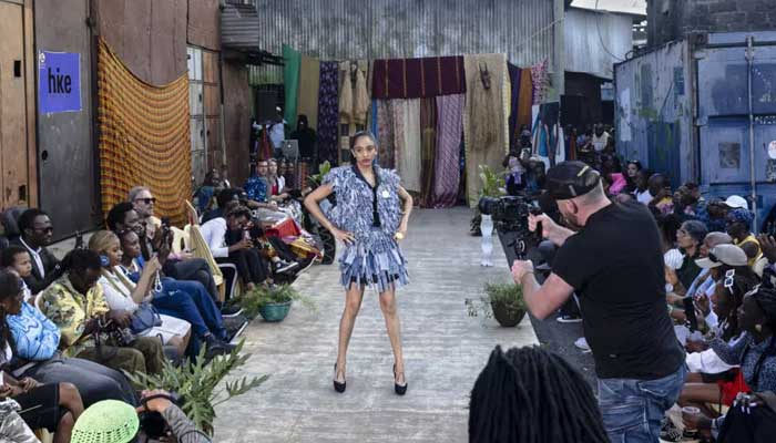 Models wear outfits created by local fashion designers specializing in recycling discarded fabrics and garments from second-hand clothing markets. — AFP