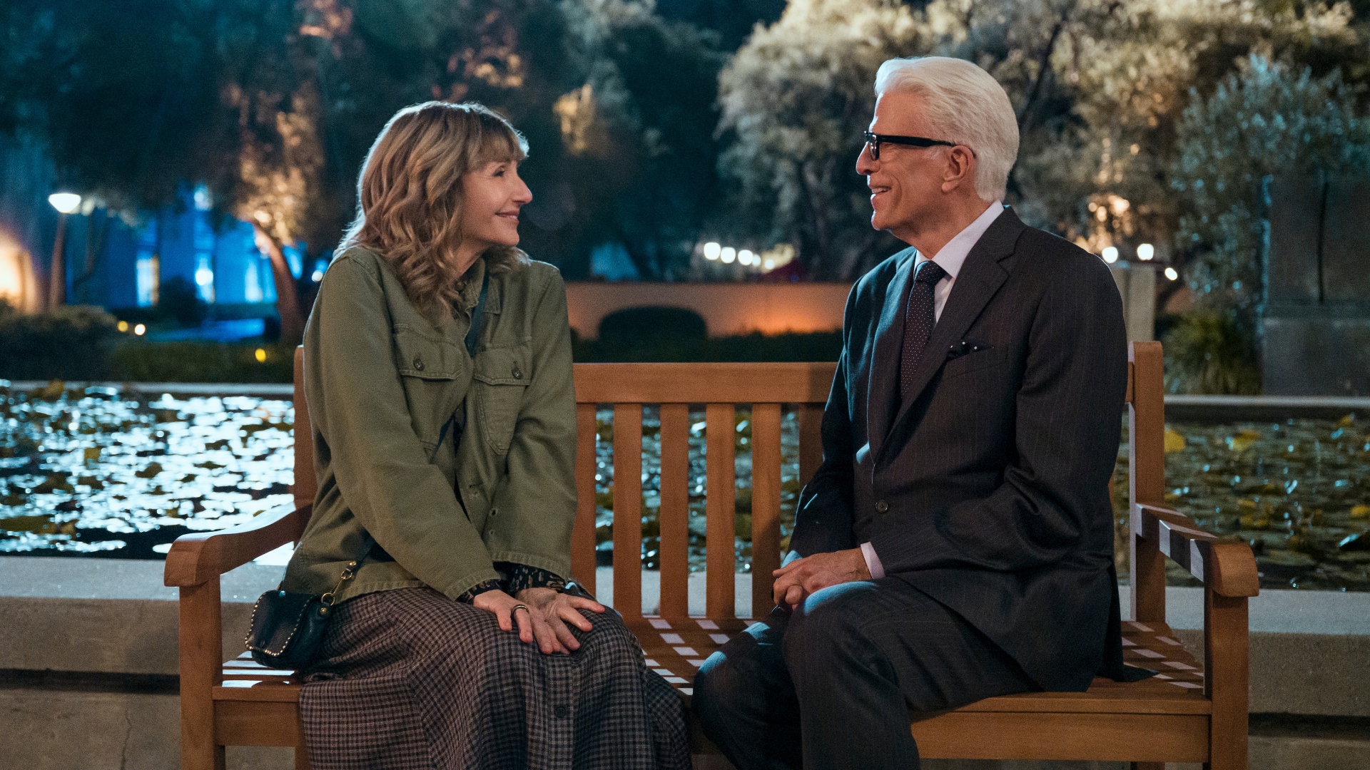 Charles and Mona sit on a bench and smile at each other in season two of A Man on the Inside.