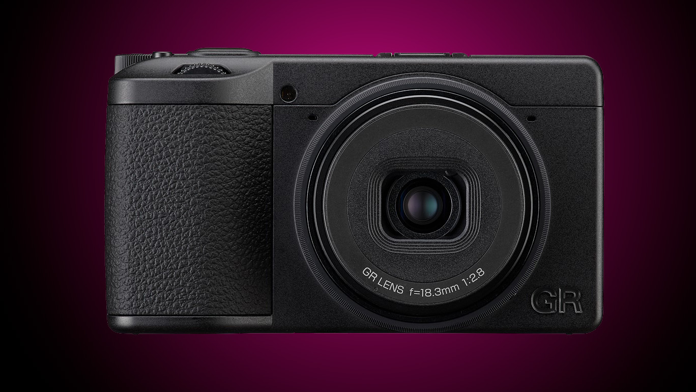 A Ricoh compact camera against a gradient purple background