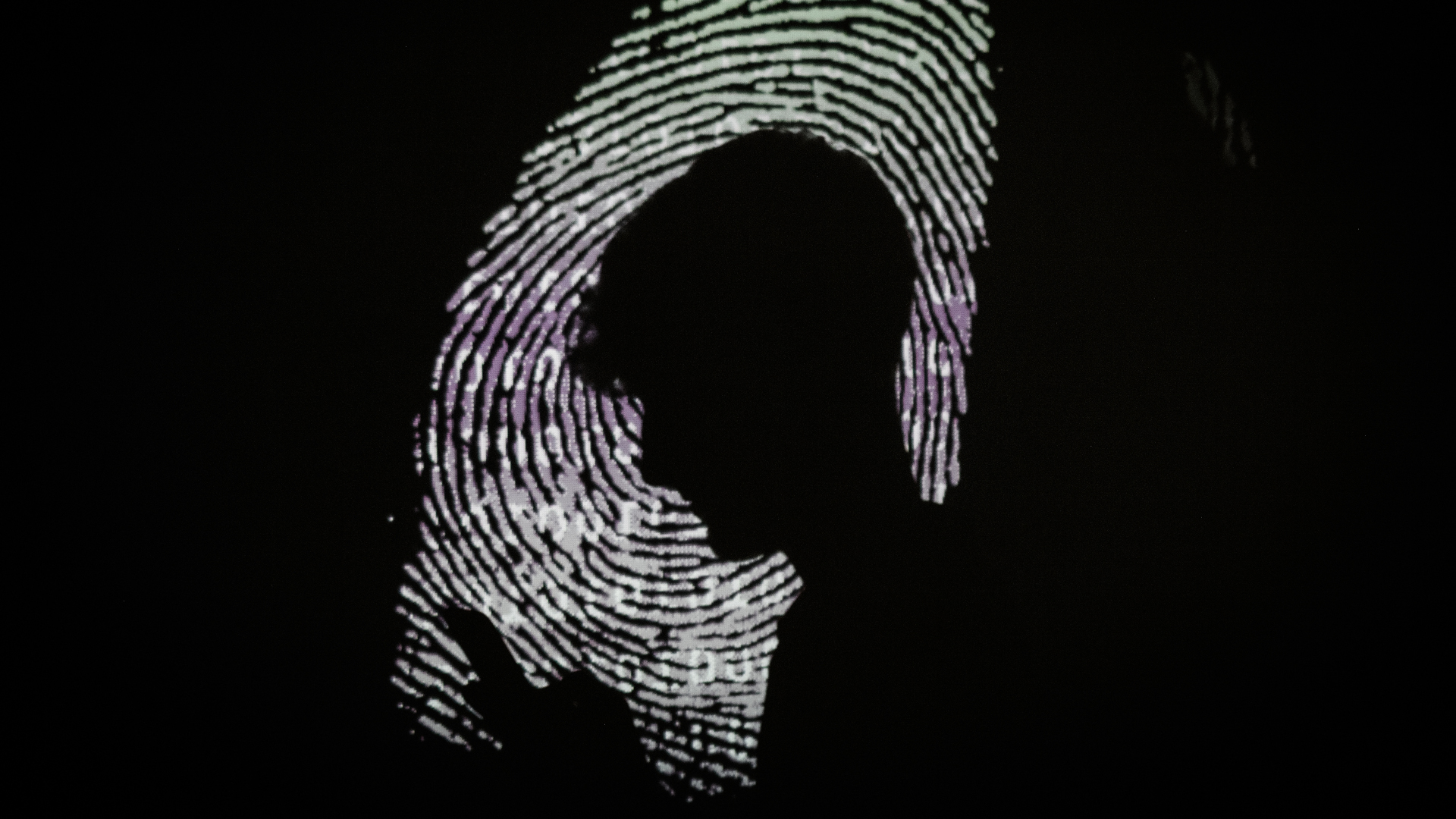 A silhouette of a boy looking at his phone on a magnified fingerprint background