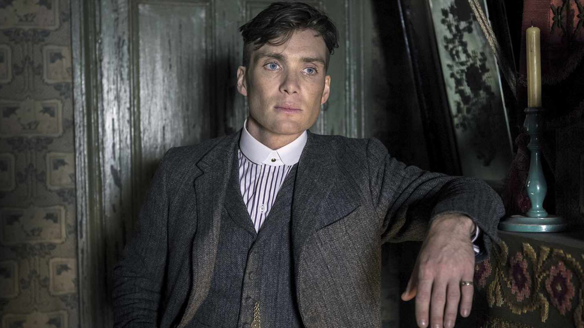 Cillian Murphy relies on a fireplace with her left arm
