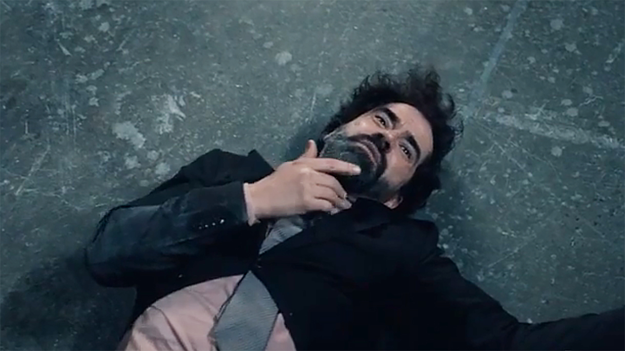 Hamish Linklater's Dough lying on the floor holding his chin with his right hand in Gen V Season 2 Episode 7