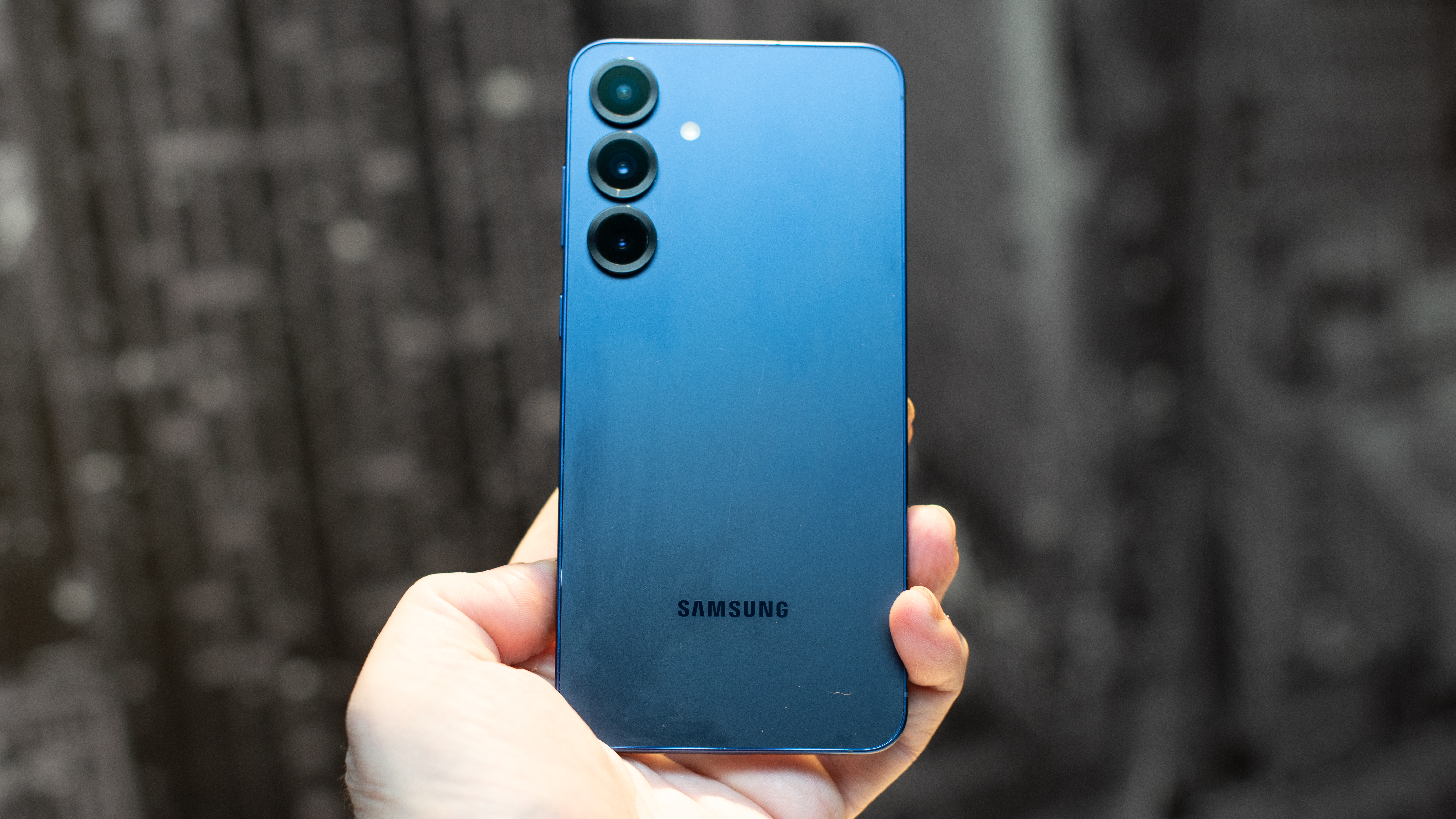 Samsung Galaxy S25 Plus in navy blue held in hand showing the back