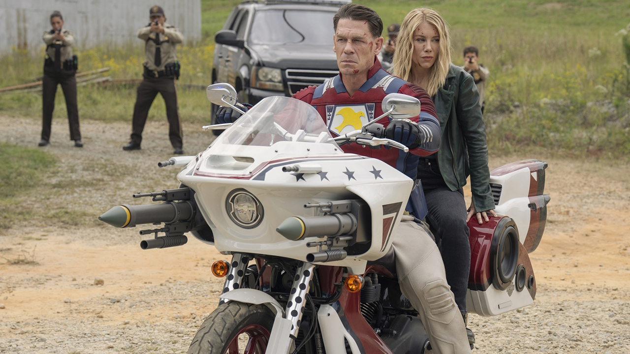 Chris Smith and Emilia Harcourt sitting in the Peace Cycle while they are surrounded by police officers in the Pacifier Season 2 Episode 7