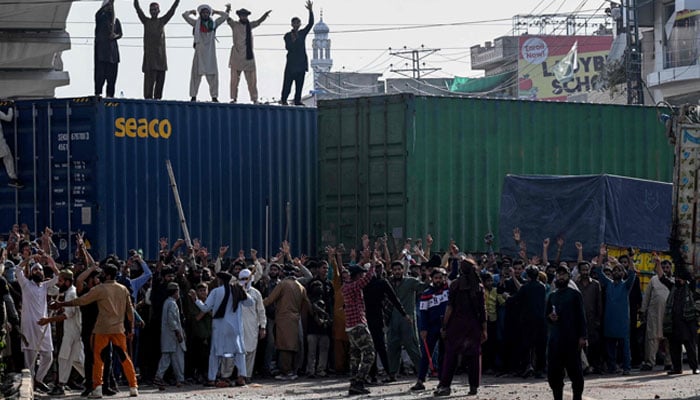Tehreek-e-Labbaik Pakistan activists shout slogans near their party headquarters in Lahore, as authorities blocked the road with shipping containers, in Lahore on October 9, 2025, before their pro-Palestinian march towards Islamabad. —AFP
