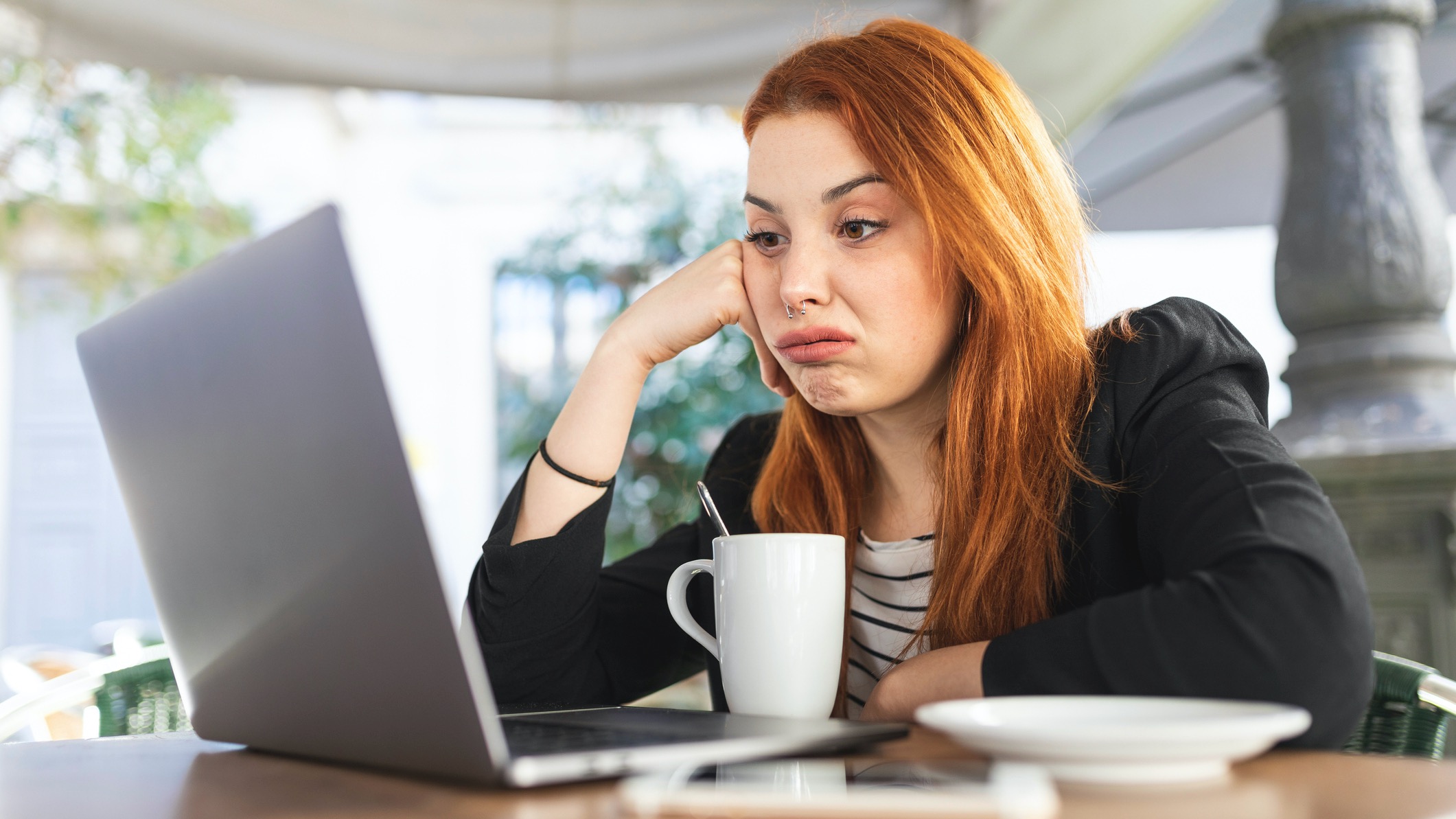Young woman using laptop, looking upset