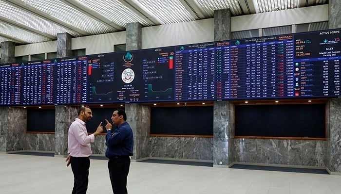 Two investors can be seen arguing in front of the digital stock board at the Pakistan Stock Exchange. — AFP/Archive