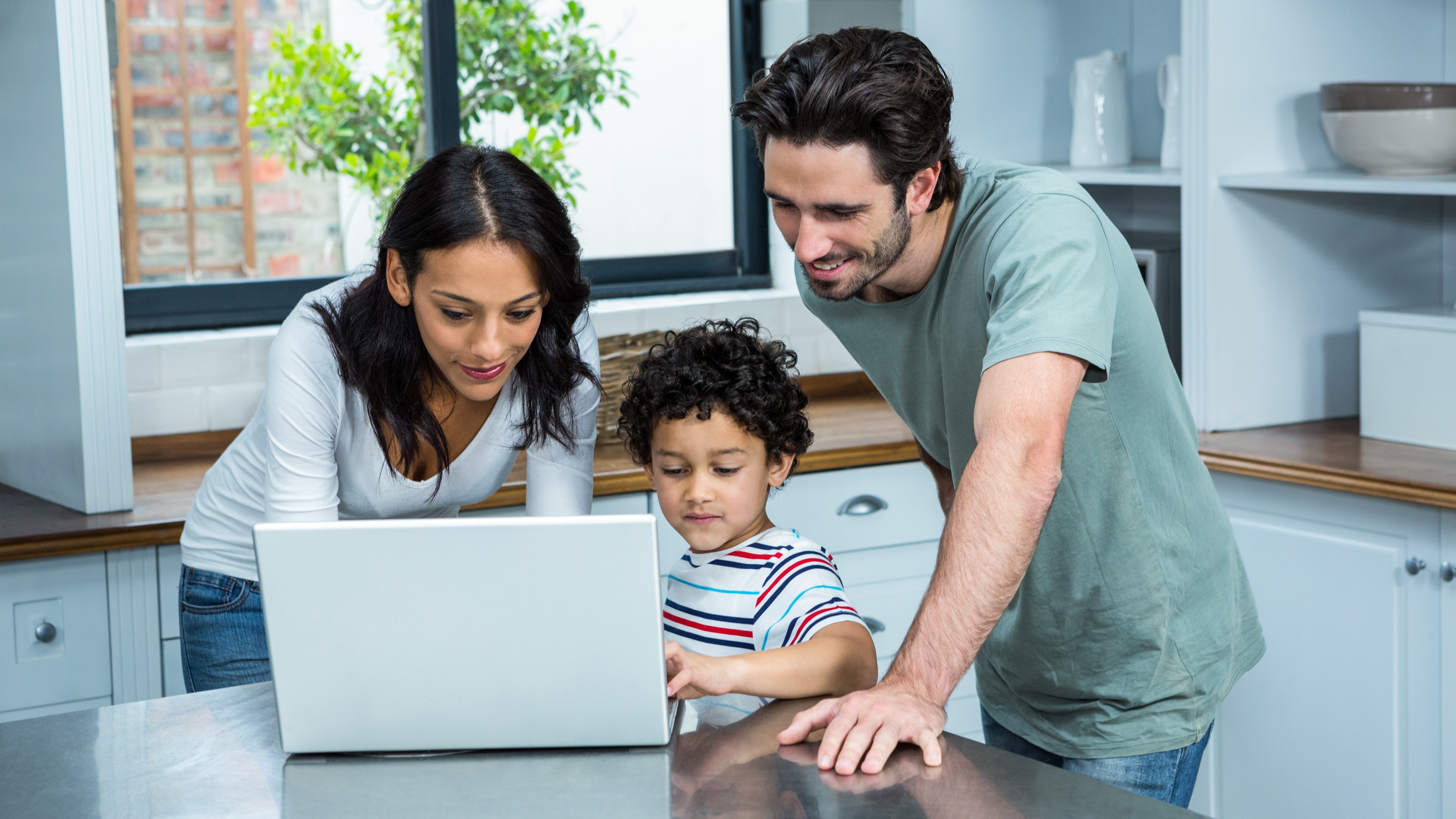Parents with children, learning from a laptop at home.