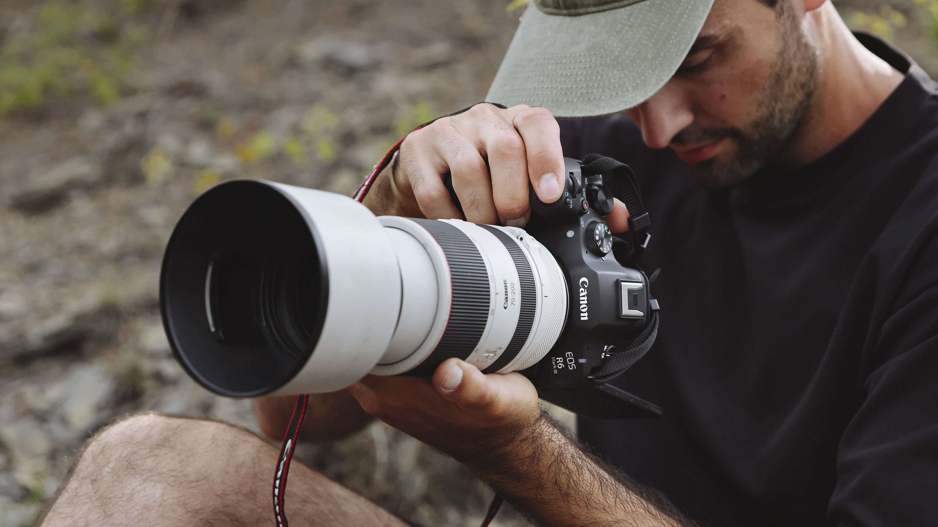 Canon EOS R6 Mark III camera with attached telephoto lens, held by a male photographer in portrait orientation
