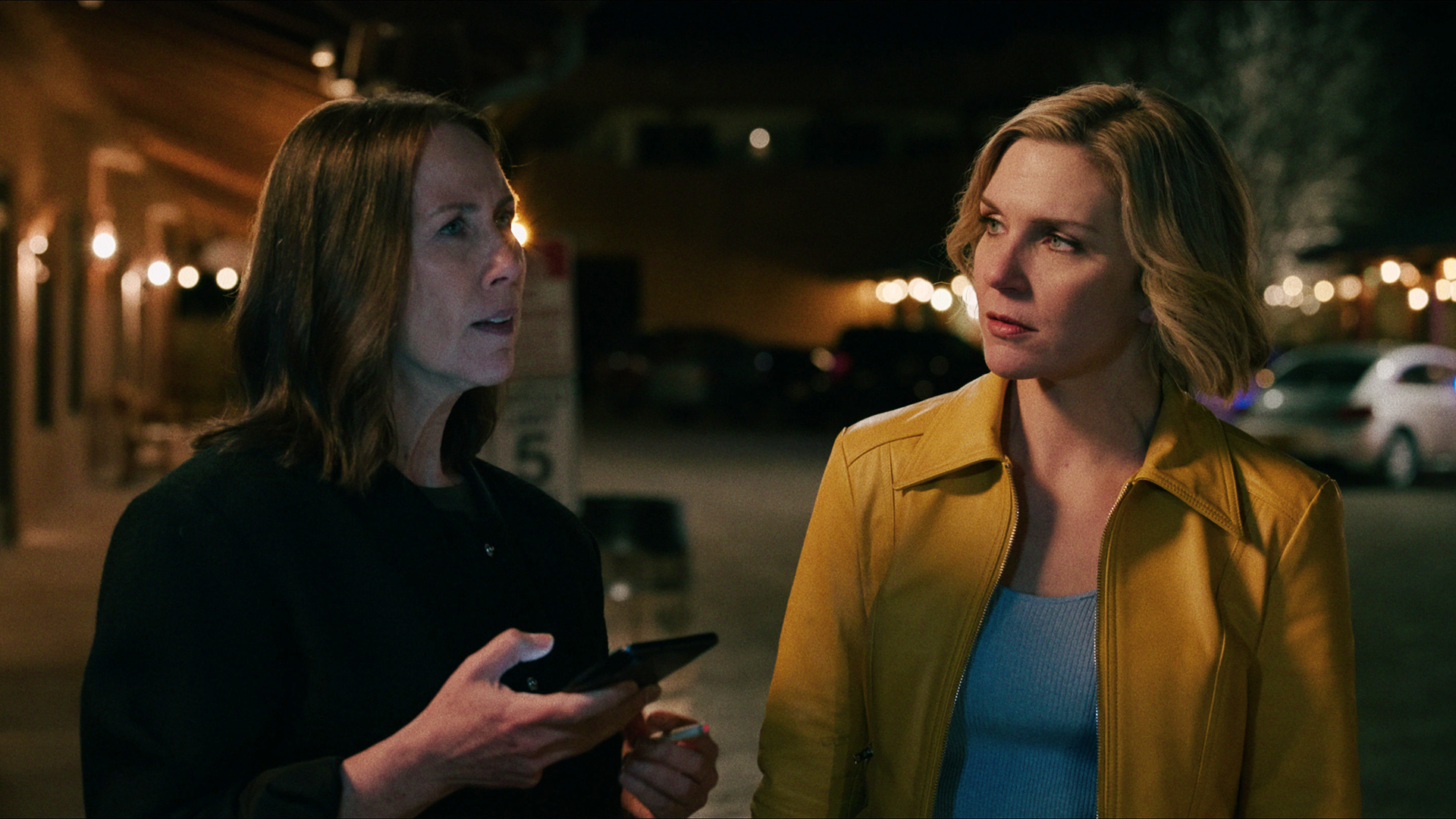 Helen holding her phone while Carol watches her in episode 1 of Pluribus.