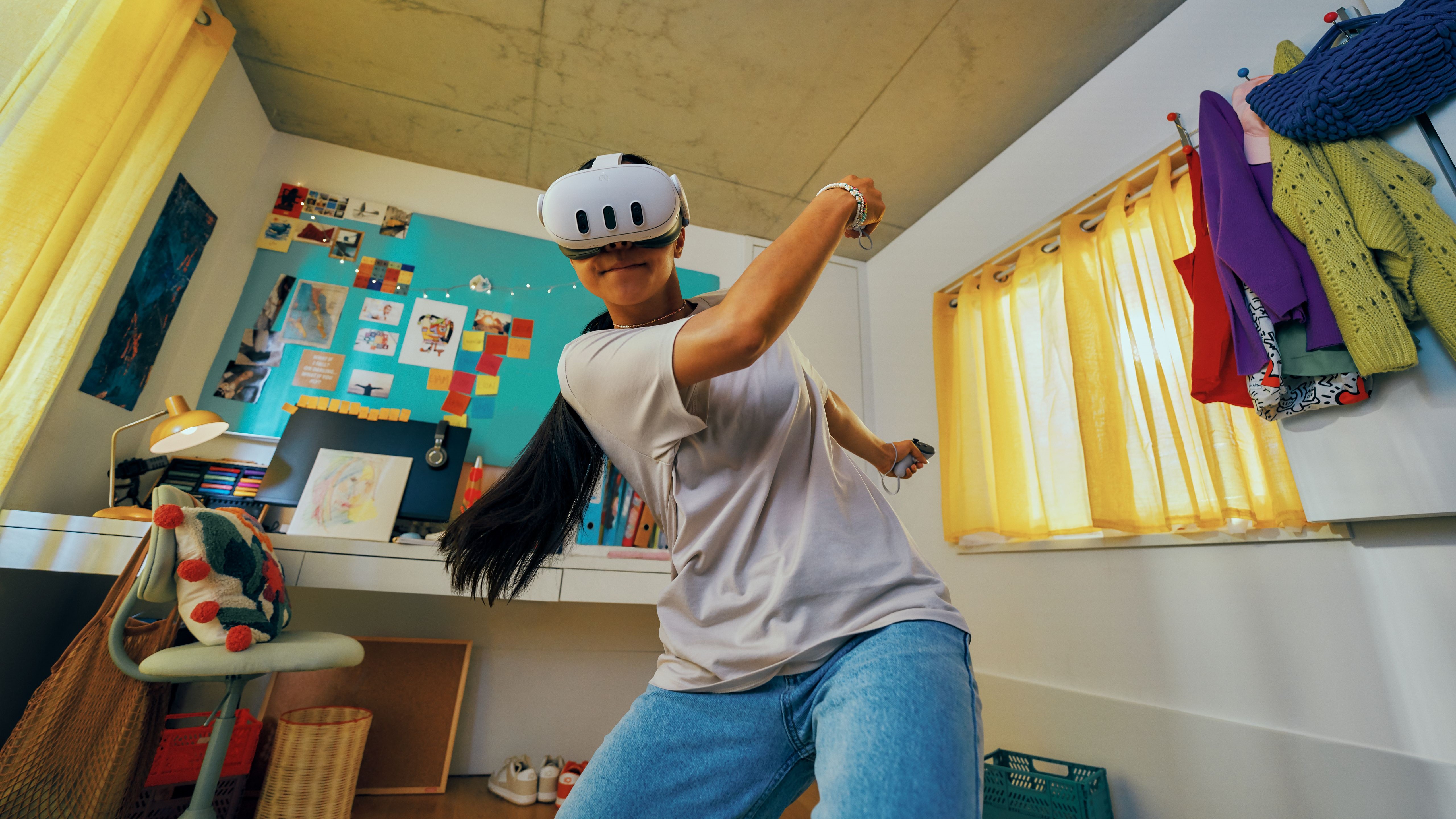 A Meta Quest 3 playing tennis in VR while in his bedroom with his desk behind him.