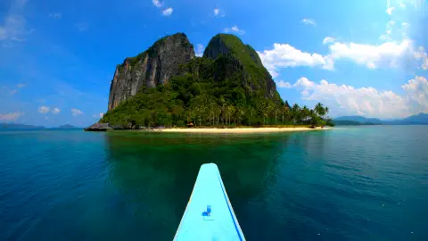 A canoe approaching an island in calm waters.