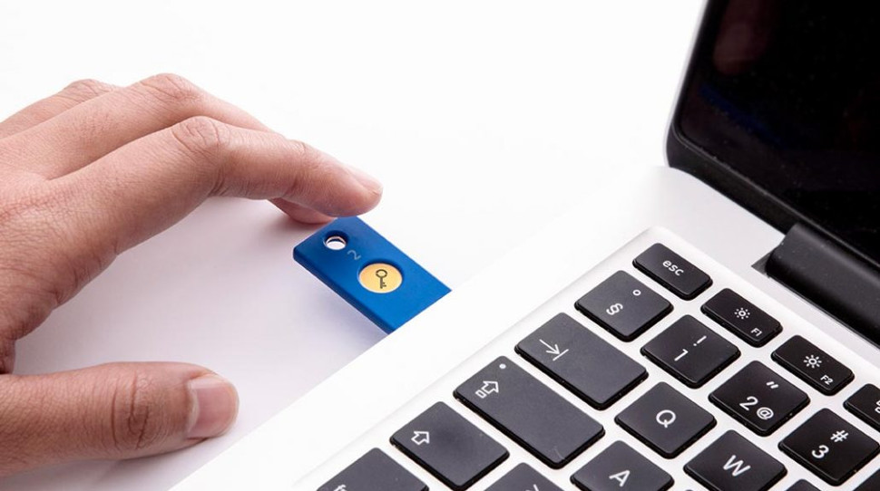 A person using a YubiKey security key with their laptop.