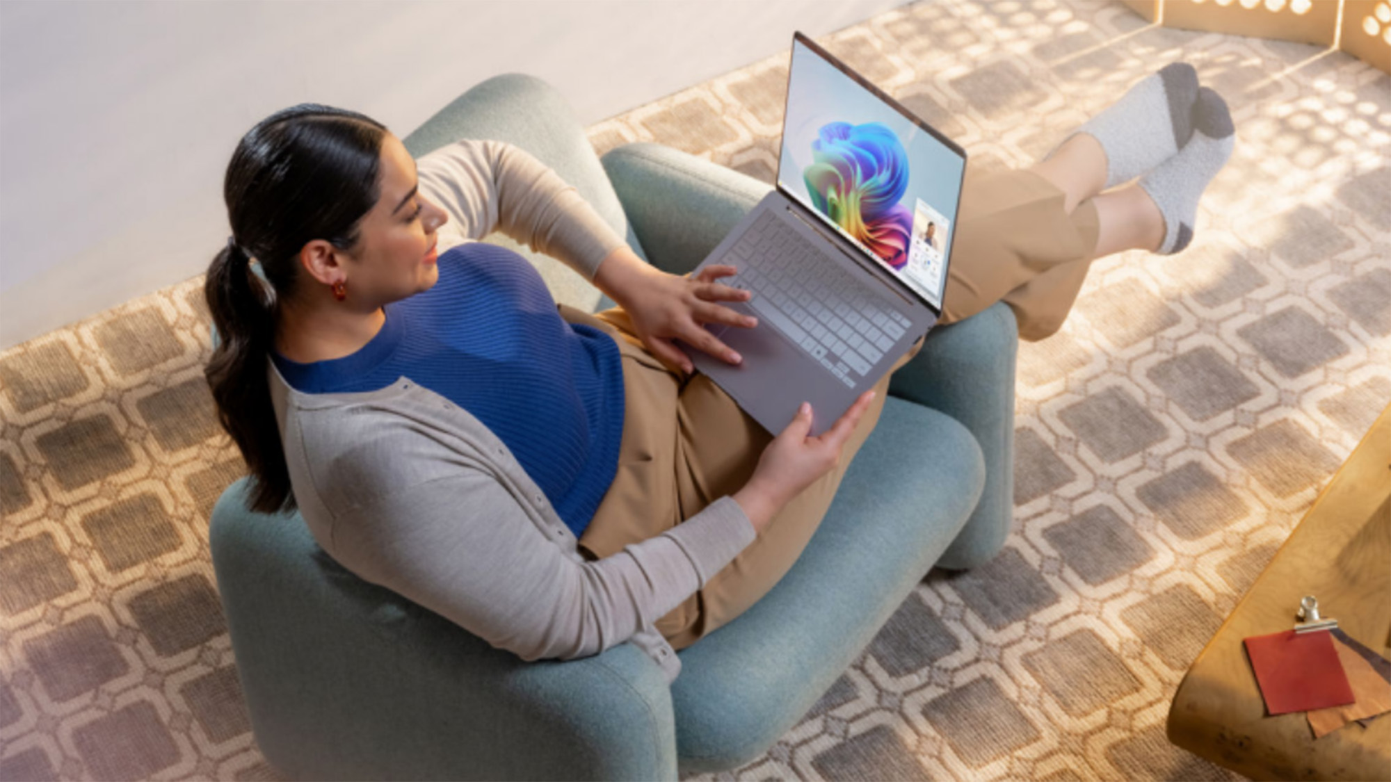 Woman sitting in a chair looking at a Windows 11 laptop