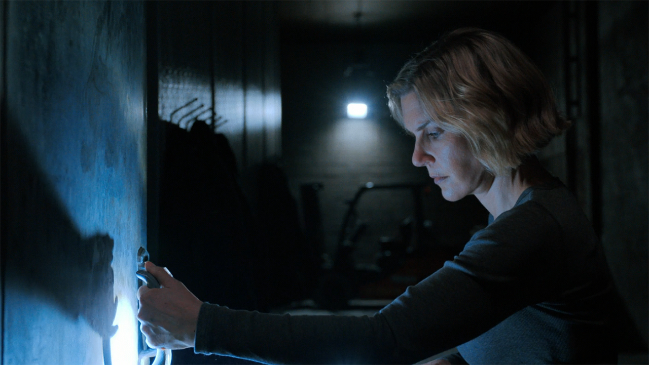 Carol looking at a refrigerator handle in a dark room in episode 5 of Pluribus.