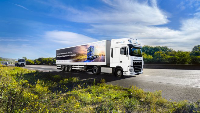 A truck driving on a highway equipped with inductive coils for wireless charging