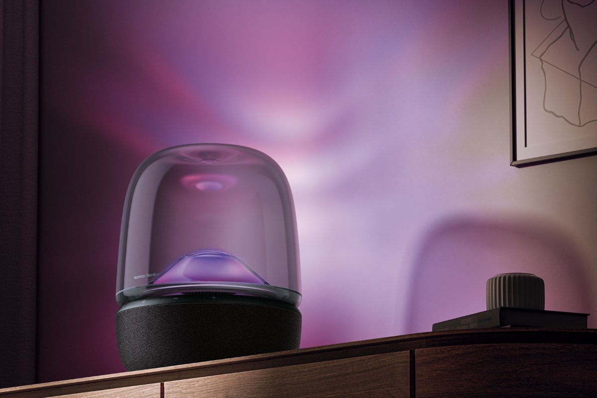 Harman Kardon Aura Studio 5, on top of a sideboard, casting a violet light on the walls