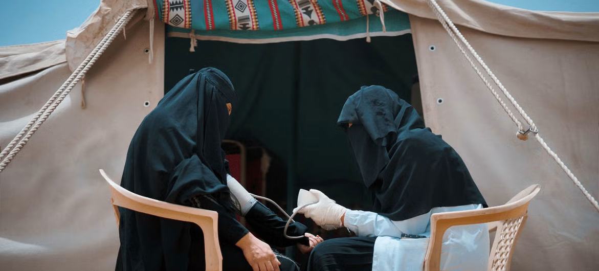 A midwife from a UNFPA mobile health clinic assesses a pregnant woman in a displaced persons camp in Marib, Yemen.
