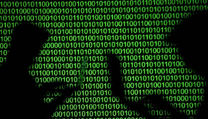 In this illustration, silhouettes of laptop users are seen next to a binary code screen projection. – Reuters