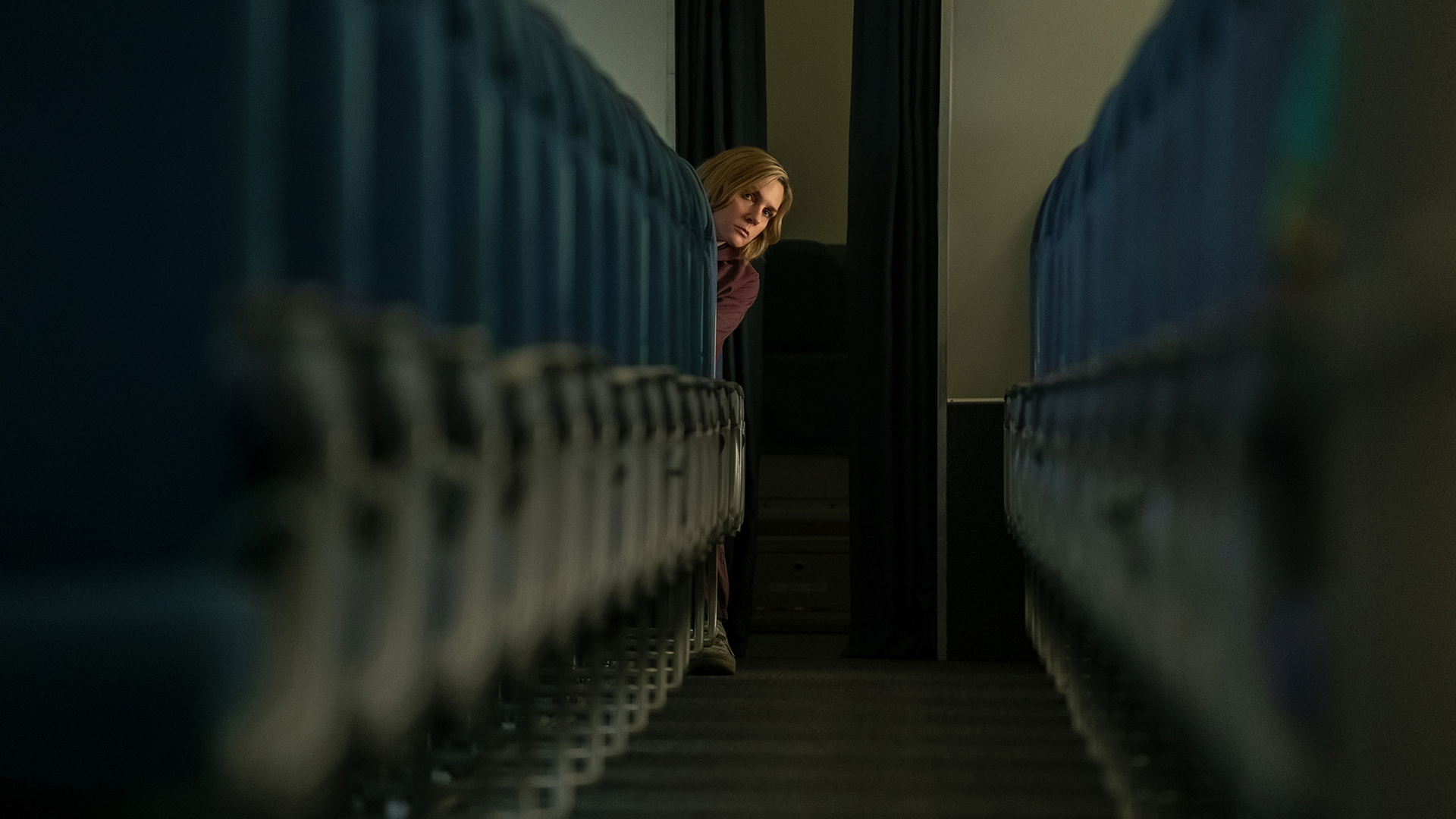 Carol leaning out from the last row of a plane in episode 3 of Pluribus