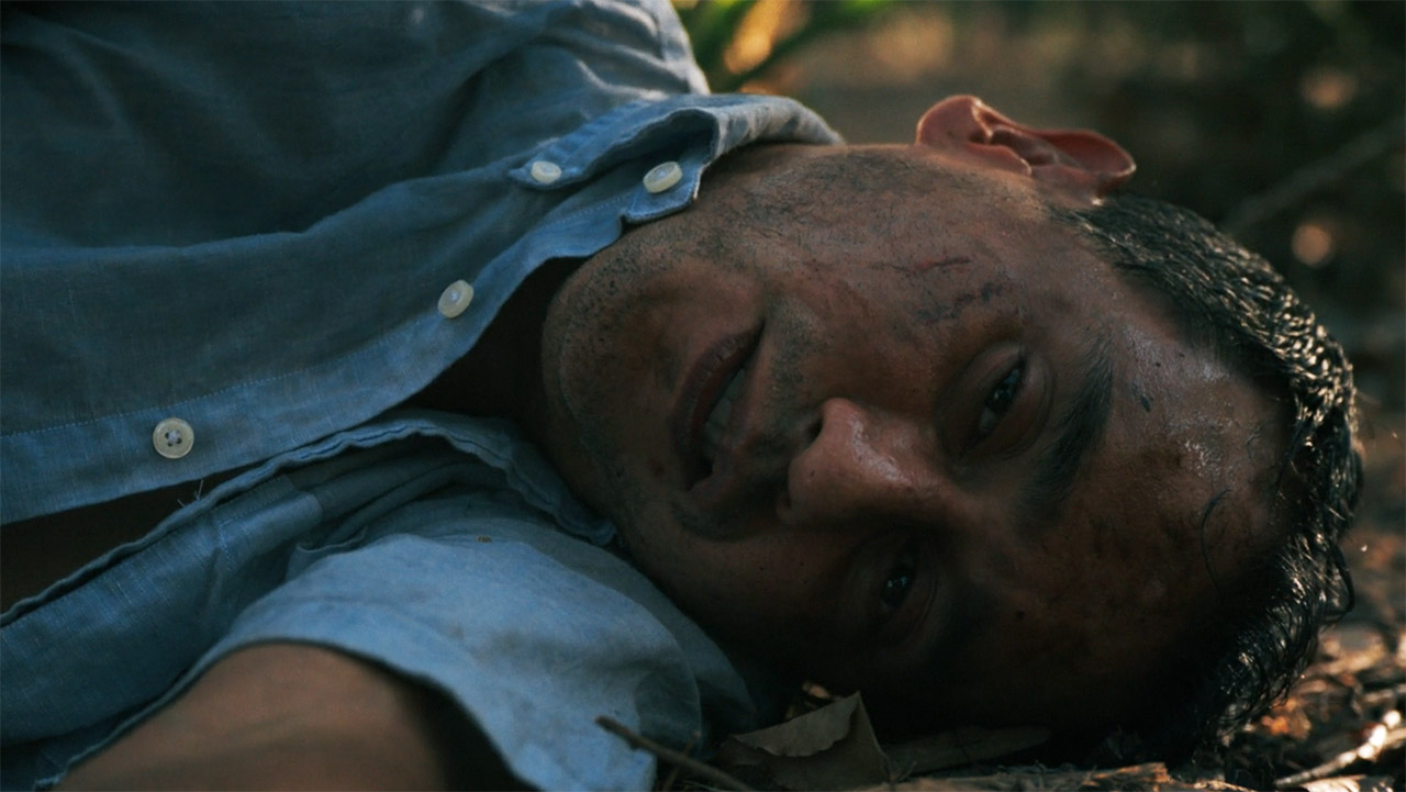 A nearly dead Manousos lying on the rainforest floor in episode 7 of Pluribus.