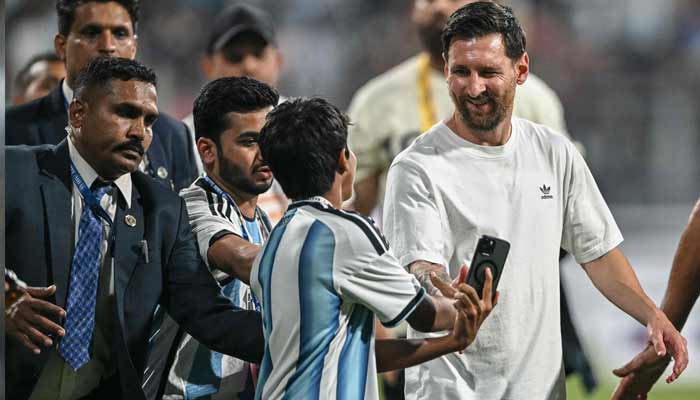 Argentine footballer Lionel Messi (right) interacts with a young fan during his Goat Tour at the Wankhede stadium in Mumbai on December 14, 2025.— AFP