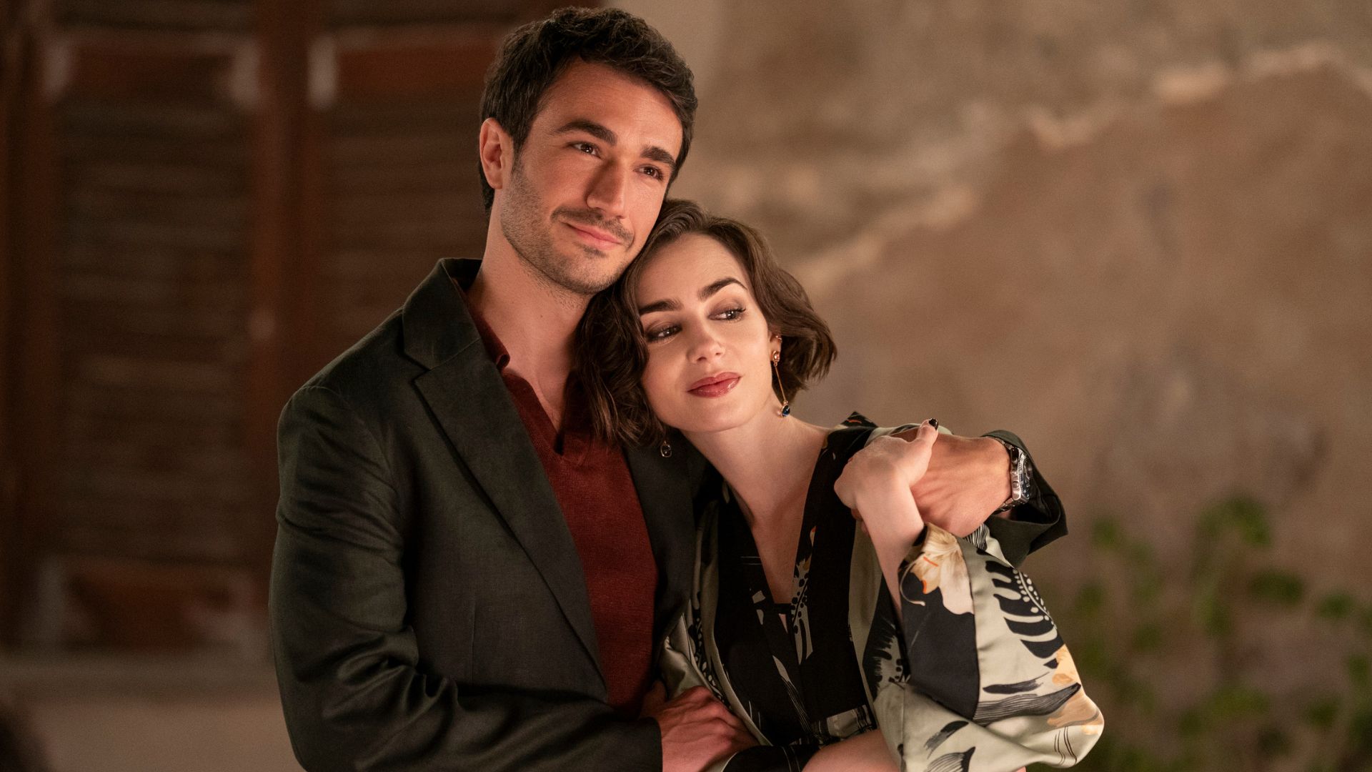 Marcello puts his arm around Emily.