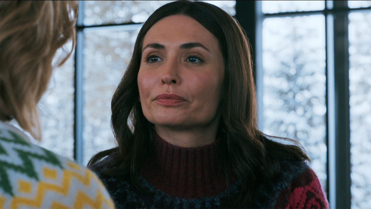 Zosia looks sad as she sits and looks at Carol off-screen in episode 9 of Pluribus.