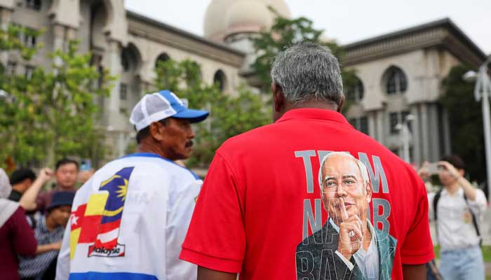 A supporter wears a T-shirt with the portrait of former Malaysian Prime Minister Najib Razak printed on it, in front of the Palace of Justice in Putrajaya, Malaysia, December 26, 2025. – Reuters