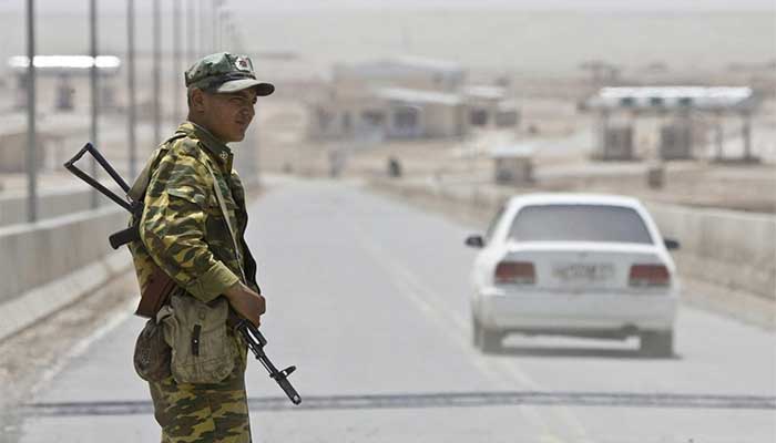 A border guard stands on a bridge into Afghanistan across the Panj River at the Panji Poyon border post, south of Dushanbe, Tajikistan, May 31, 2008. - Reuters