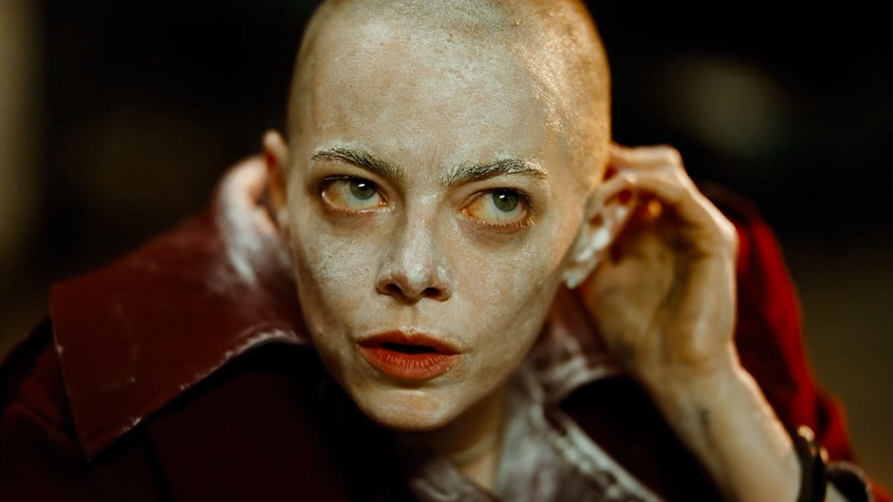 Emma Stone's Michelle wearing white makeup and with a shaved head in Bugonia