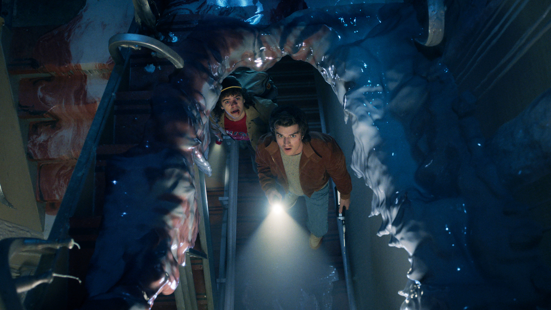 Dustin and Steve looking through a wrecked truck in Stranger Things season 5