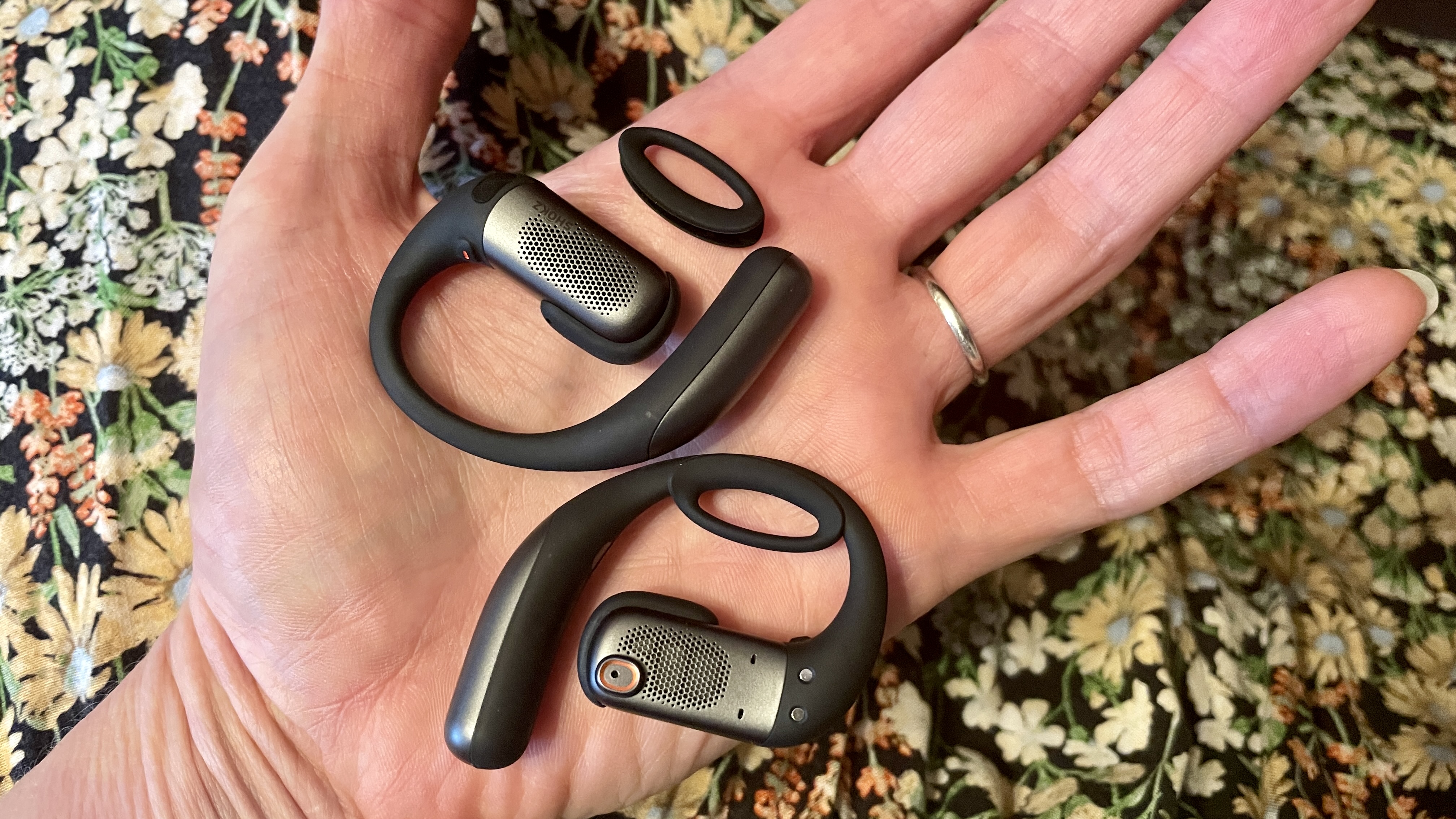 Highlighting the small safety rings of the Shokz OpenFit Pro, which are easy to put on
